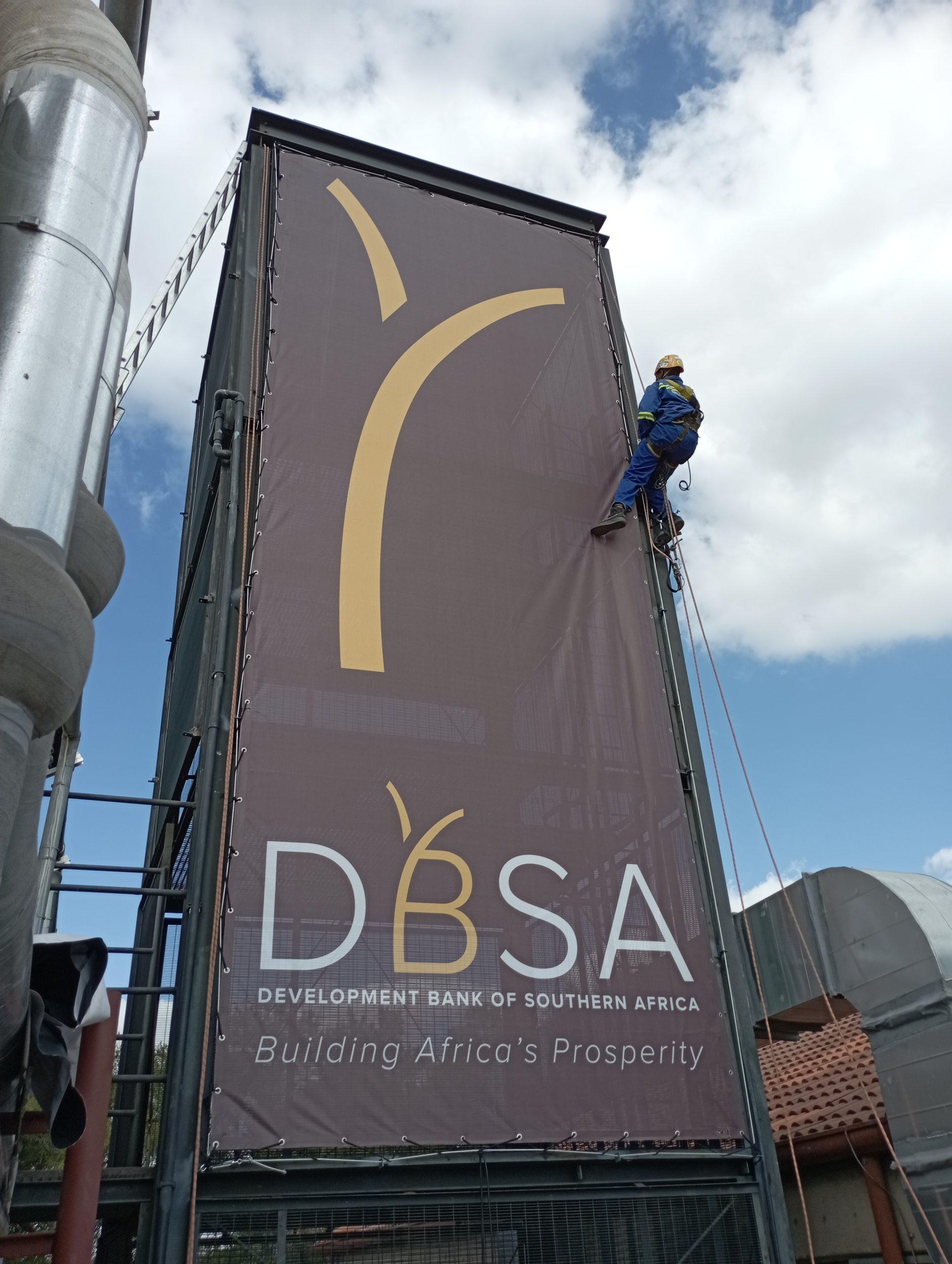 Installation of stretch signage at a business property by Masproclean Branding and Signage